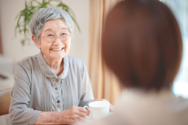 笑顔で若い女性と話す高齢女性