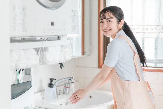 手を洗うエプロン姿の女性