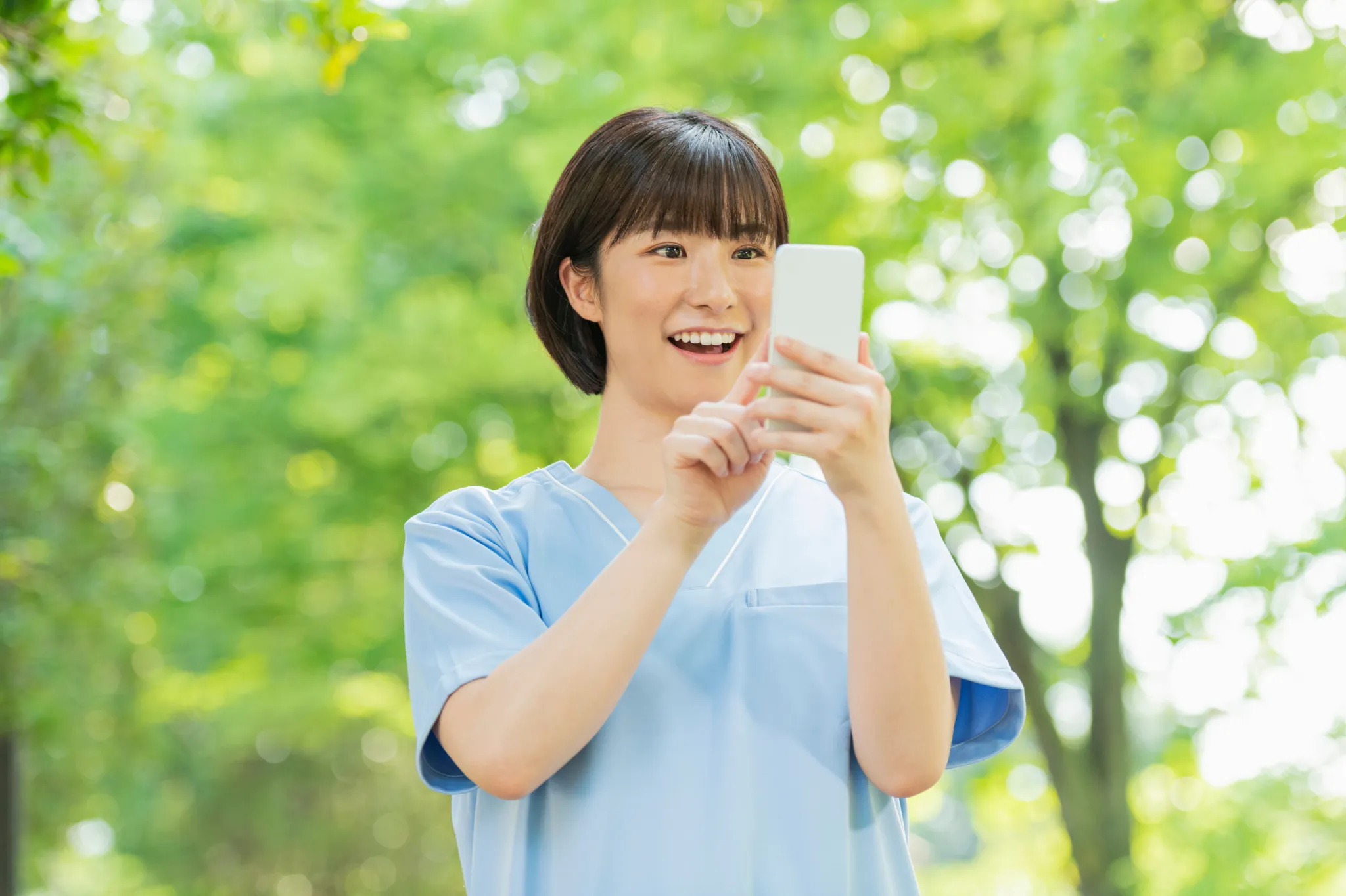 スマートフォンを見る介護職の女性