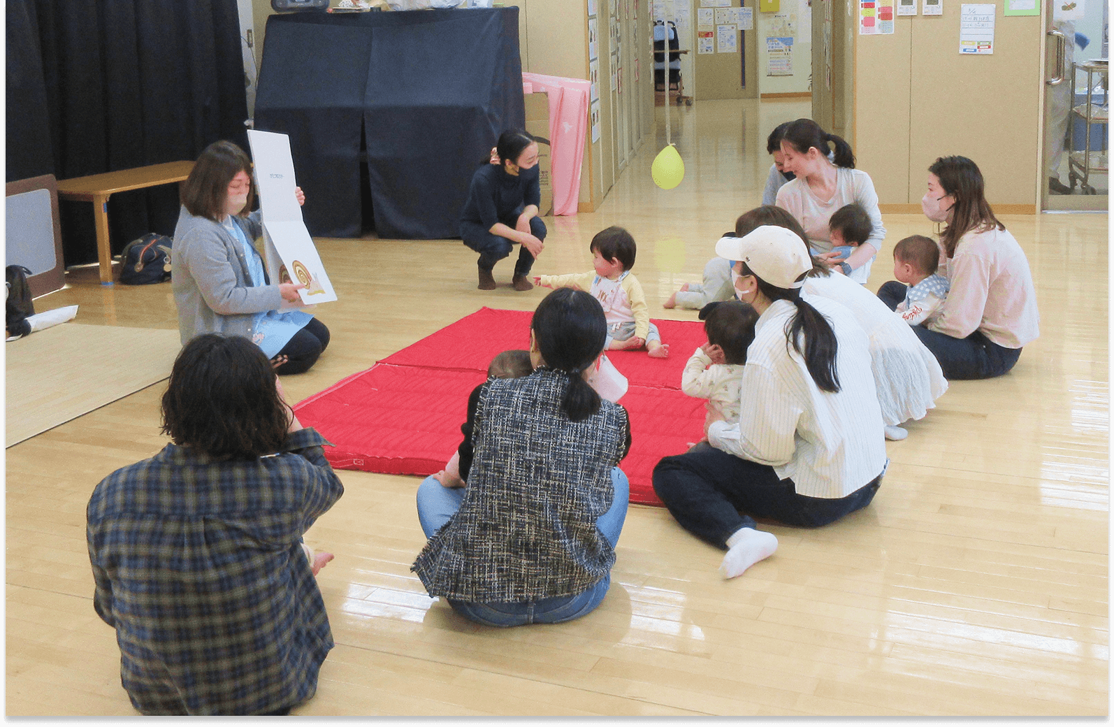 保育園で楽しそうに並ぶ子どもたちと保育士